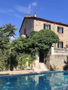 a building and a swimming pool in front of a house at Villa Carmen del Rosal in Miraflores de la Sierra