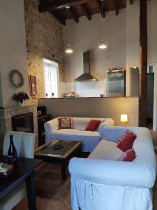 a living room with two couches and a table at Villa Carmen del Rosal in Miraflores de la Sierra