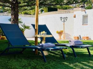 two chairs and a table in the grass at Casa Laura by Sun & Sea Homes in Moraira