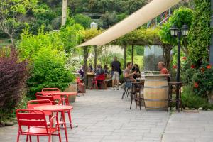 a patio with tables and chairs and a barrel at Parcelas Chill-Outdoor in Perarrua +8 photos