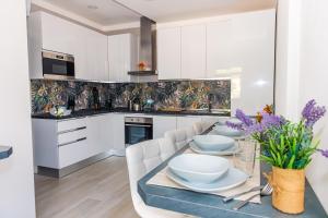 a kitchen with white cabinets and a table with white dishes at Affittacamere 911 in Paratico