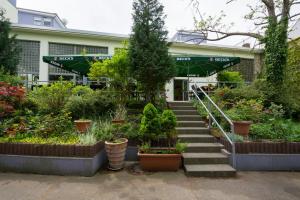 a garden with potted plants in front of a building at Familienhotel Citylight in Berlin