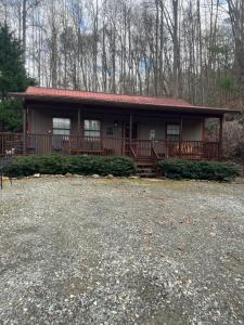 a small house with a large porch in the woods at Blue Mist Mountain Retreat in Whittier