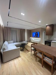 sala de estar con sofá, mesa y piano en Tirana LUX Apartments, en Tirana
