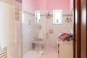 Baño de color rosa con aseo y lavamanos en Casa Preziosa, en Sorrento