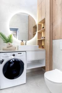 a bathroom with a washing machine and a sink at SuperApart Mińska Apt 3 - Blisko Stadionu Narodowego in Warsaw +9 photos