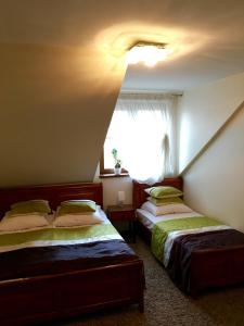 a bedroom with two beds and a window at Dworek w Dawnej Szkole in Sieradz