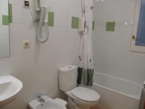 a bathroom with a toilet and a sink and a phone at Hostal La Vila in Olot