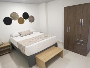 a bedroom with a bed and a wooden cabinet at HOTEL A & A SANTA ALEJANDRIA in Medellín