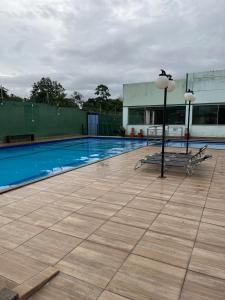 einen Pool mit zwei Stühlen und einer Laterne in der Unterkunft Apartamento em Belém- cop30 in Ananindeua
