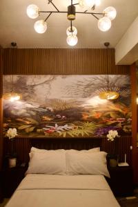 a bedroom with a large painting on the wall at Manhattan Parkway Araneta City U7i in Manila