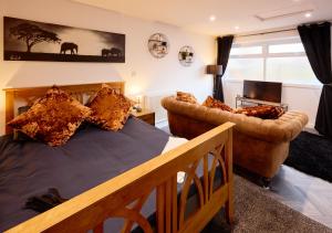 a bedroom with a bed and two couches at A Stylish & Welcoming Apartment in Middlesbrough