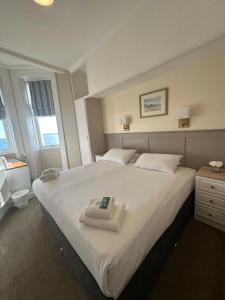a bedroom with a large bed with a towel on it at Clarence House Hotel in Tenby