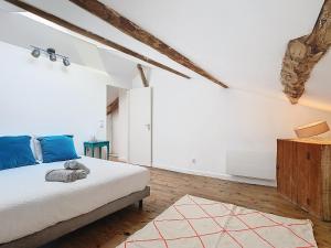 a bedroom with white walls and a bed with blue pillows at 1 2 3 Soleil, Piscine, Lac, 5 chambres, 12 pers in Saint-Pierre