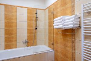 a bathroom with a shower and a tub and towels at Hotel Slovan in Jeseník +94 photos
