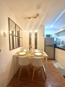 a dining room table with chairs and a kitchen at EDSA Cozy 3BR near MRT w Netflix and Karaoke Fun in Manila