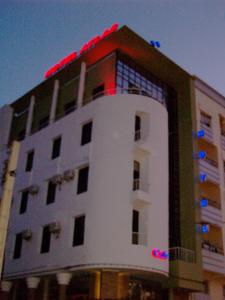 Hôtel Atlas Guercif في خرسيف: مبنى طويل وبه أضواء حمراء فوقه