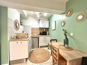 a kitchen with a table and a dining room at Studio le nid rouennais, calme en hypercentre in Rouen
