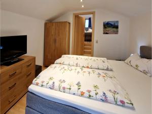 a bedroom with a bed with a floral bedspread at Turmhaus in Schönau am Königssee