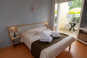 a bedroom with a bed with towels on it at Vacances Bleues Club Keravel in Carnac