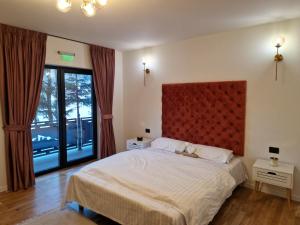 a bedroom with a large bed with a red headboard at Vila Timeea in Statiunea Borsa