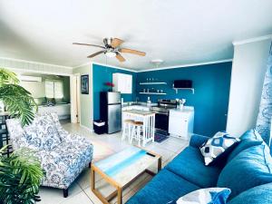 a living room with a blue couch and a kitchen at Playa Esmeralda INN unit #1 in Bradenton Beach