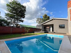 a swimming pool in front of a house at Casa Iguazú 121 in Puerto Iguazú