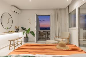 una camera da letto con un letto, un tavolo e delle sedie di Seanfinity Beachfront Suites a Mikri Vigla