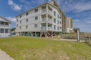 a large apartment building with a lawn in front of it at Oceanfront North Myrtle Beach Condo with Patio! in Myrtle Beach