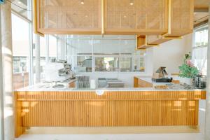 a kitchen with a wooden counter top and windows at Ellipse Boutique Phayao in Phayao