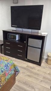 a entertainment center with a flat screen tv on it at BlissPoint Inn FKA Motel 6t7 in Indianapolis