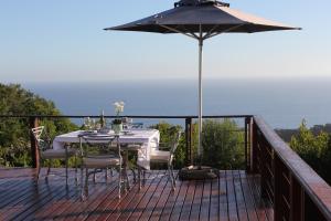ウィルダネスにあるTURACO HOUSEのテーブルと椅子、パラソル付きのデッキ