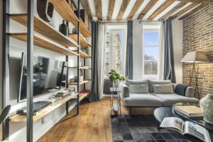 Una sala de estar con un sofá y un televisor. en Ghost, en París