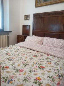 a bedroom with a bed with a floral bedspread at Villa Erbetta in Guardabosone
