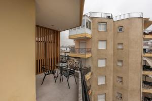 a balcony with chairs and a table next to a building at City Vibe Center Family Flat 3 in Thessaloniki