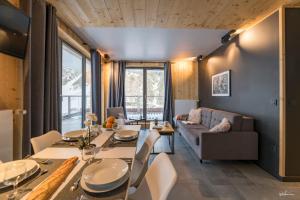 a dining room with a table and a couch at Résidence Lagrange Vacances L'Ecrin du Badet in Aragnouet