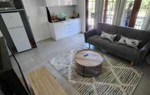 a living room with a couch and a table at Gorgeous Garden Villa 2 in Gillitts-Emberton