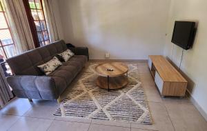 a living room with a couch and a coffee table at Gorgeous Garden Villa 2 in Gillitts