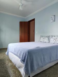 a white bedroom with a bed with a blue blanket at Apartamento São Pedro da Aldeia frente para lagoa in São Pedro da Aldeia
