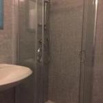 La salle de bains est pourvue d'une douche avec une porte en verre. dans l'établissement Hotel Aurora, à La Spezia