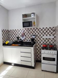 a kitchen with a stove and a microwave at kitNet mobiliada de 1 quarto in Contagem