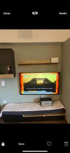 a flat screen tv on a wall above a bed at Ourania26! in Glyka Nera