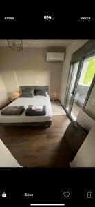 a bedroom with a bed in a room with a window at Ourania26! in Glyka Nera