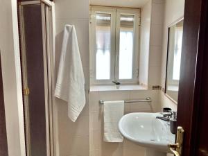 a white bathroom with a sink and a window at Corredera Cordoba in Córdoba
