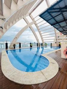 a large swimming pool on the roof of a building at Cozy 2 BR 2 Bath Condo with Netflix and Karaoke near MRT EDSA in Manila
