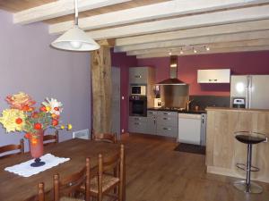 eine Küche und ein Esszimmer mit einem Tisch und einer Vase aus Blumen in der Unterkunft gite les gardes in Saint-Pierre-de-Côle