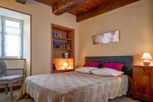 ein Schlafzimmer mit einem Bett mit rosa Kissen in der Unterkunft gite les gardes in Saint-Pierre-de-Côle + 14 Fotos