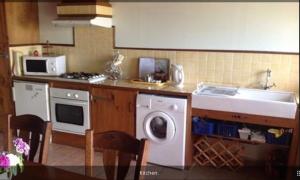 a kitchen with a washing machine and a sink at Grange Cottage in Saint-Dolay