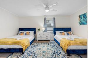 una camera da letto con due letti e un ventilatore a soffitto di Outdoor Games, Firepit, King bed, BBQ Grill, Close to Downtown and attractions a Tampa