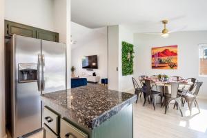 Il comprend une cuisine équipée d'un réfrigérateur et d'une table avec des chaises. dans l'établissement Spacious Yard, Sparkling Pool & Spa, Firepit, 9beds!, à Indio